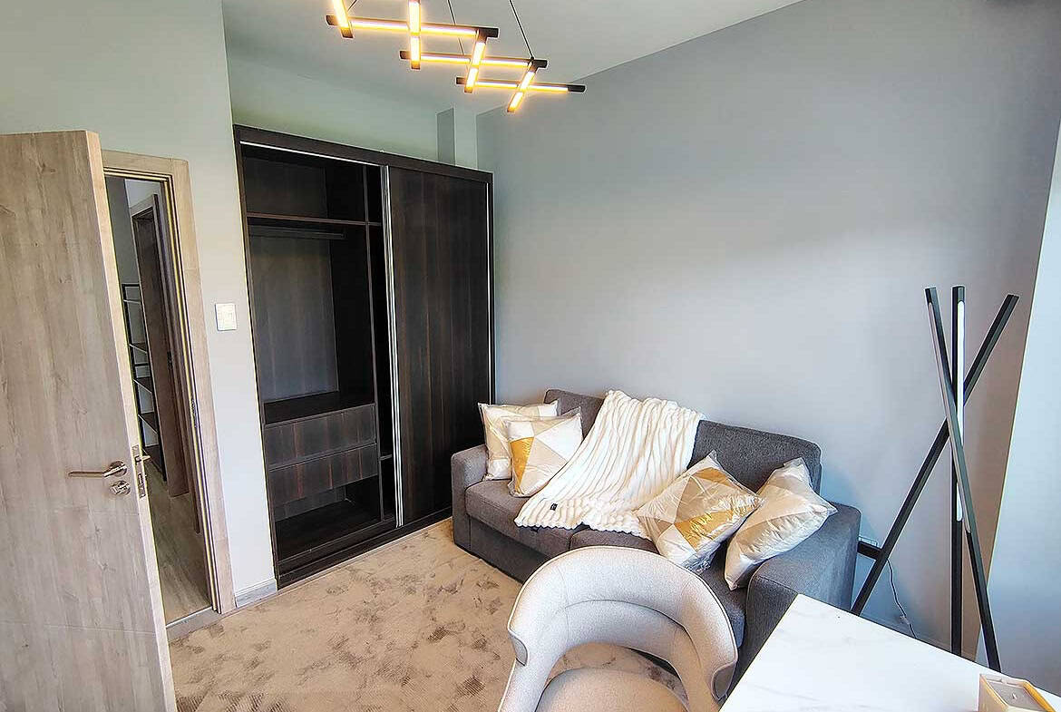 Contemporary living room with gray sofa, decorative pillows, and modern lighting.
