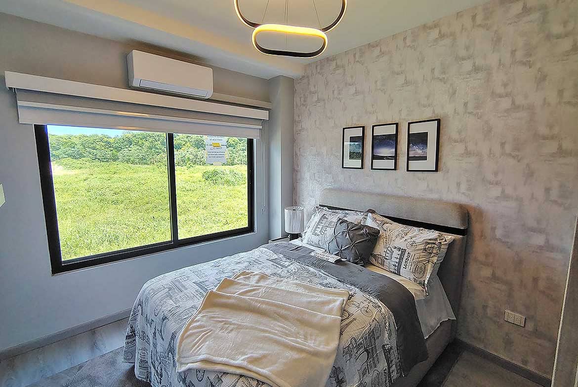 Contemporary bedroom with large window and stylish decor at Ella Vista Gardens.