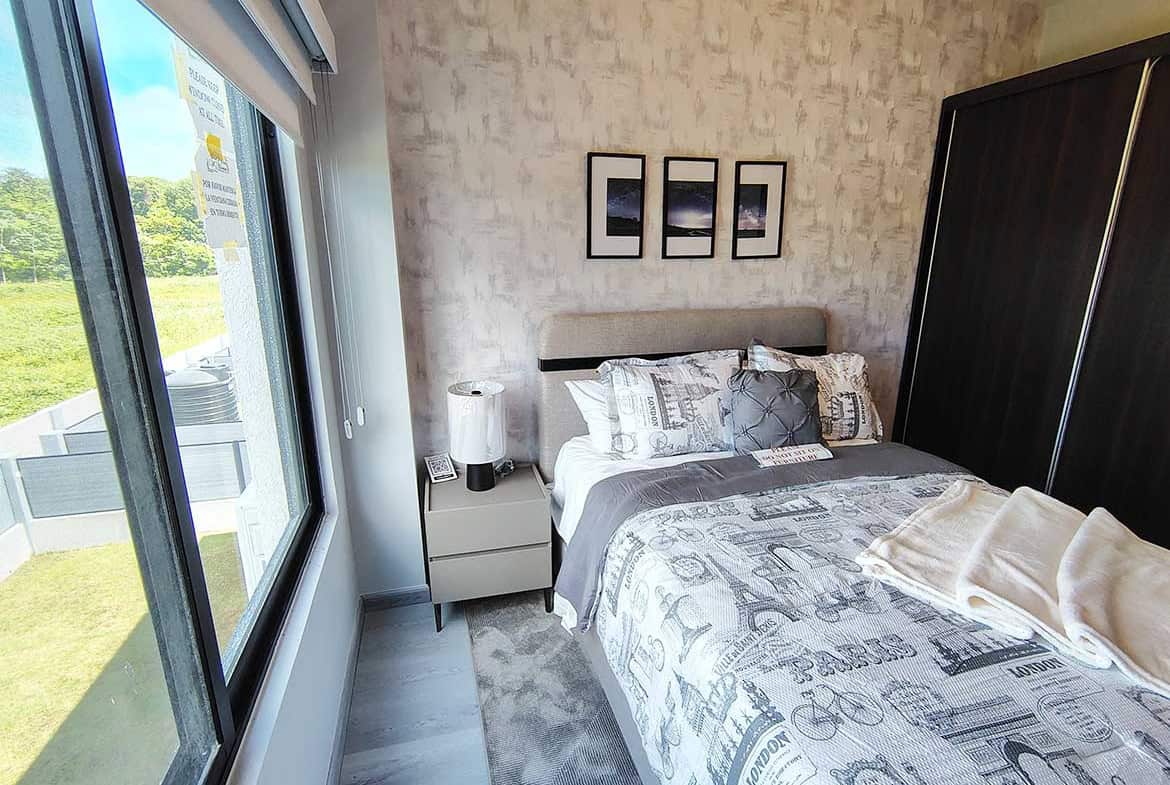 Bright modern bedroom with large window and stylish decor at Ella Vista Gardens.