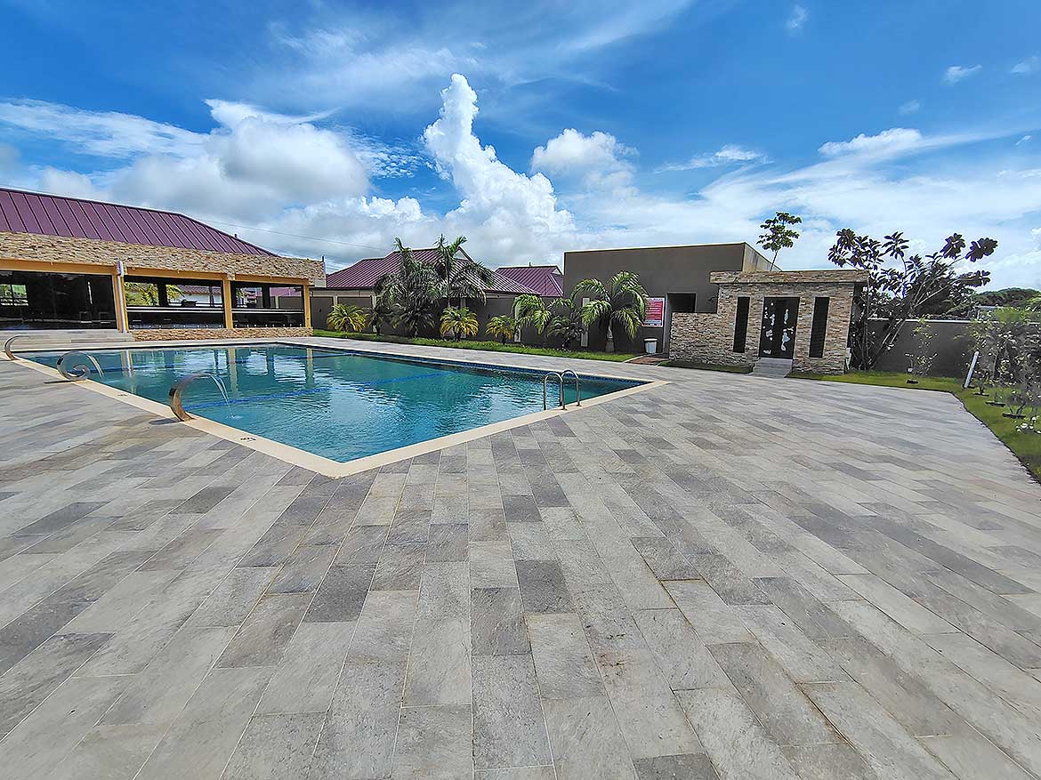 Cornerstone™ Ella Vista Gardens Pool Area Outdoor swimming pool at Ella Vista Gardens with surrounding patio and lush greenery.