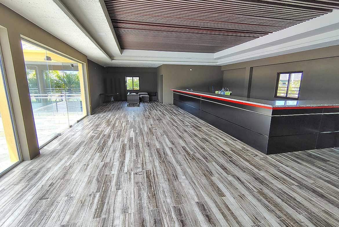 Spacious modern interior with large windows and sleek bar area at Ella Vista Gardens.