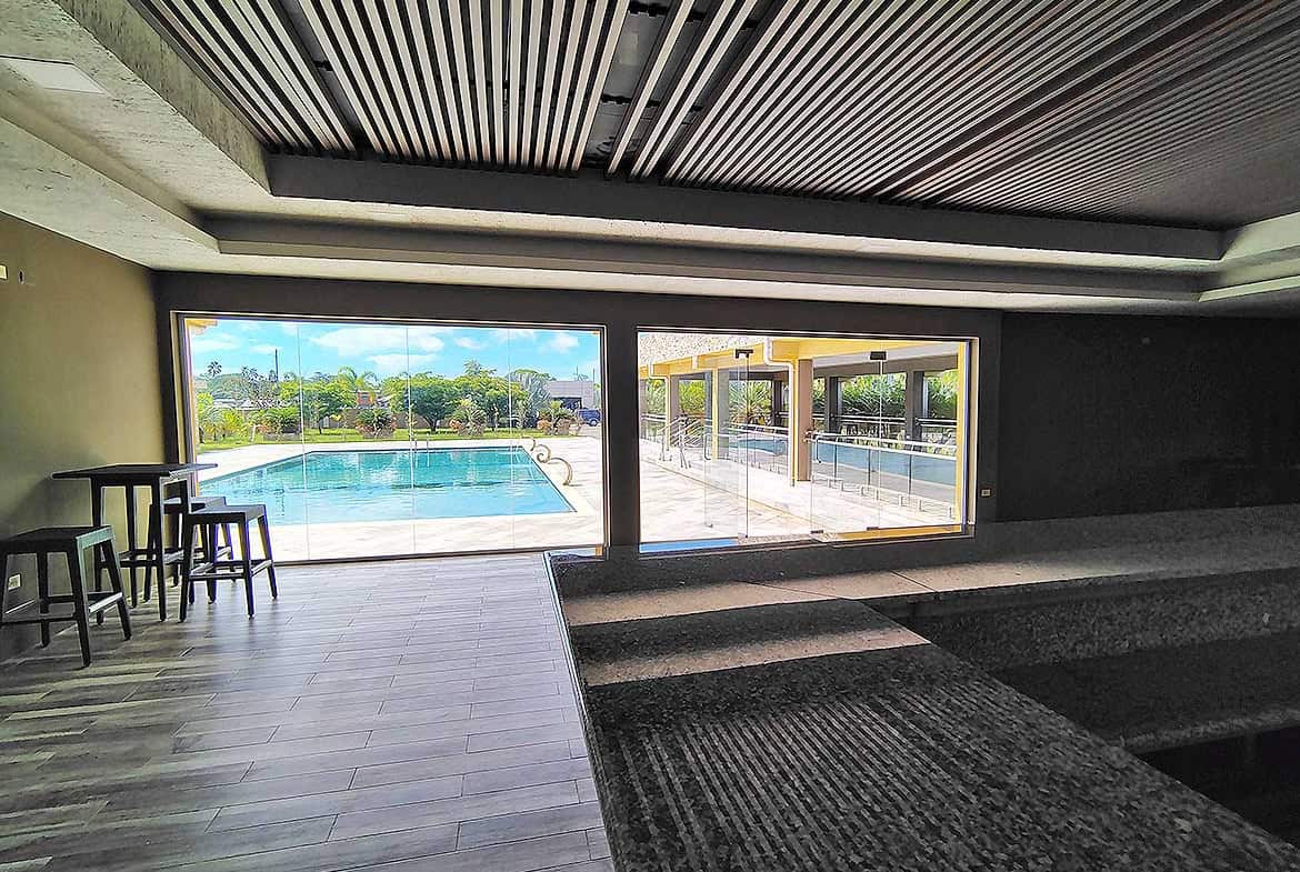 Modern pool area at Ella Vista Gardens with seating and scenic view.