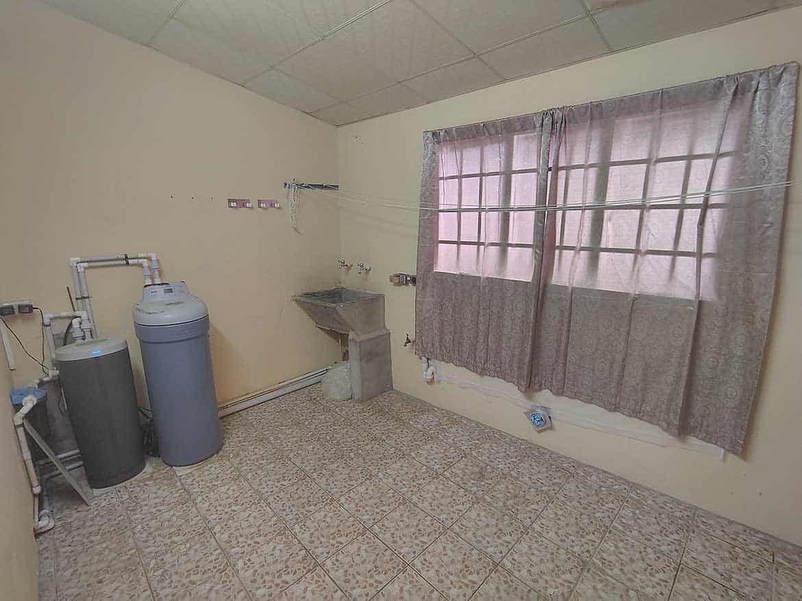 Empty Room with Water Filter System Cornerstone- Empty room with water filter system and window with curtains.