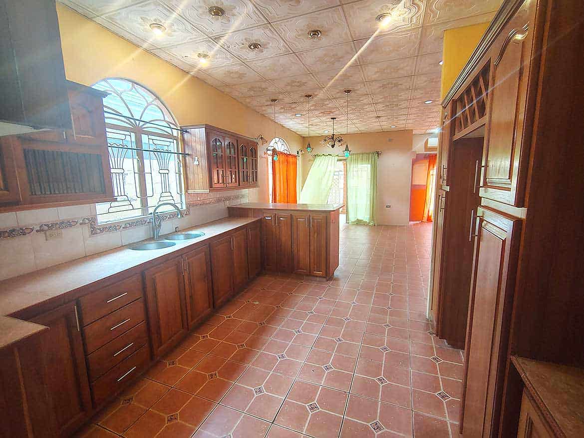 Spacious Kitchen in Cleaver Road, Arima Cornerstone- Bright kitchen with wooden cabinets and tiled floor in Arima.
