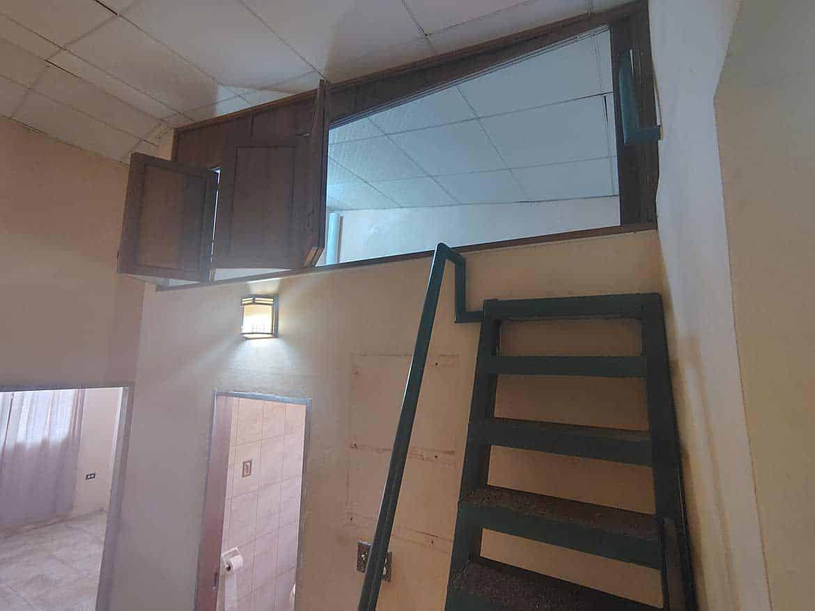 Interior View of Cornerstone™ Property Cornerstone- Interior staircase leading to a glass door with open window shutters.