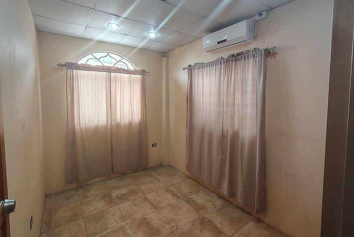 Cornerstone- Interior room with beige curtains and air conditioning unit.