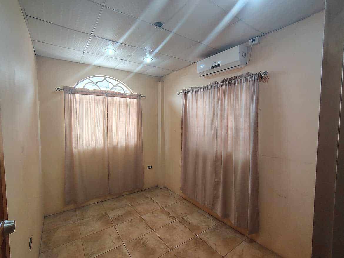 Cornerstone™ Residential Interior Cornerstone- Interior room with beige curtains and air conditioning unit.