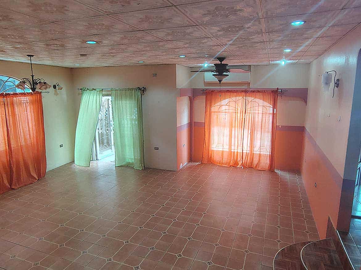 Spacious Living Room in Cleaver Road, Arima Cornerstone- Bright living room with colorful curtains and tiled floor in Arima property.