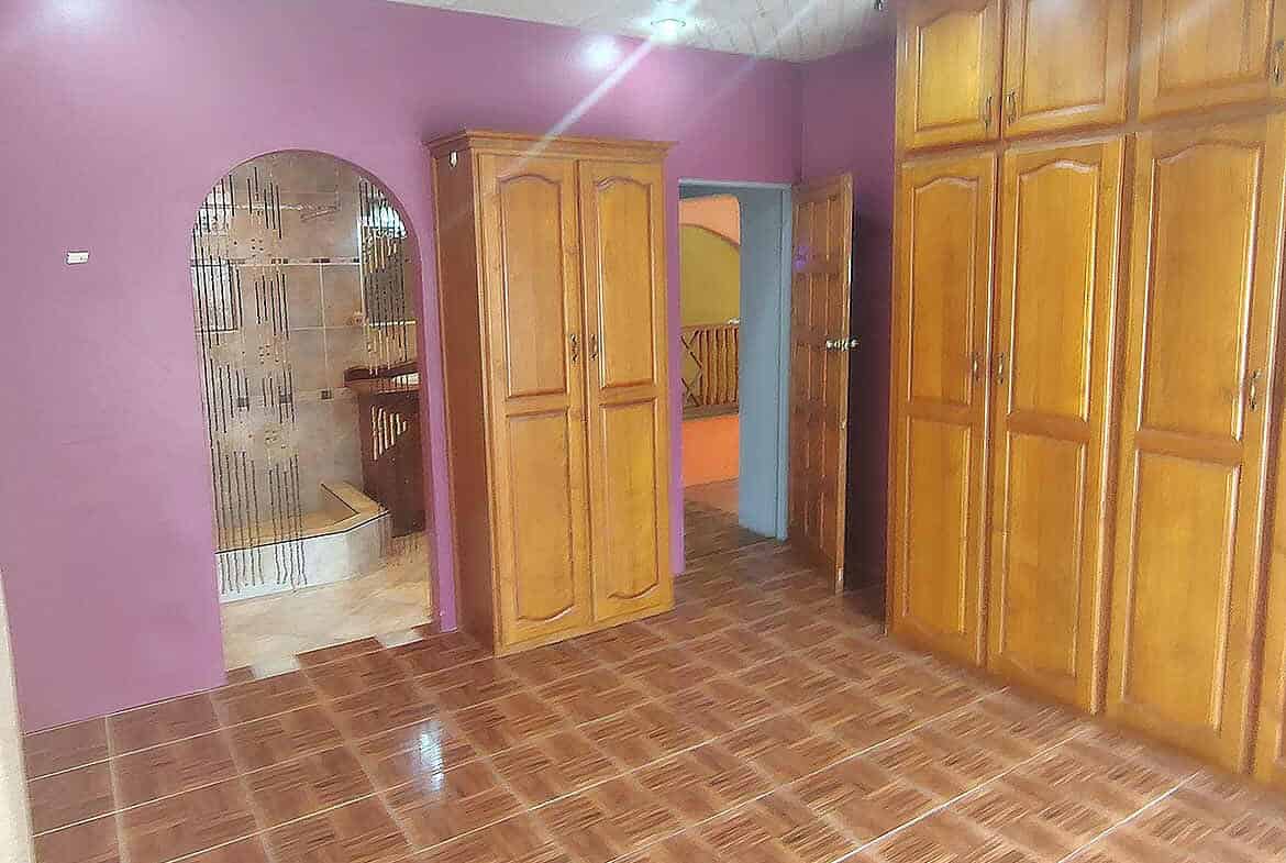 Cornerstone- Room with purple walls and large wooden wardrobes and cabinets.