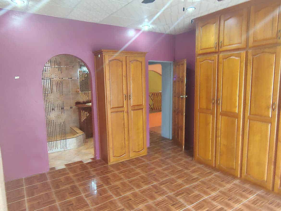 Interior of a Room with Wooden Cabinets Cornerstone- Room with purple walls and large wooden wardrobes and cabinets.