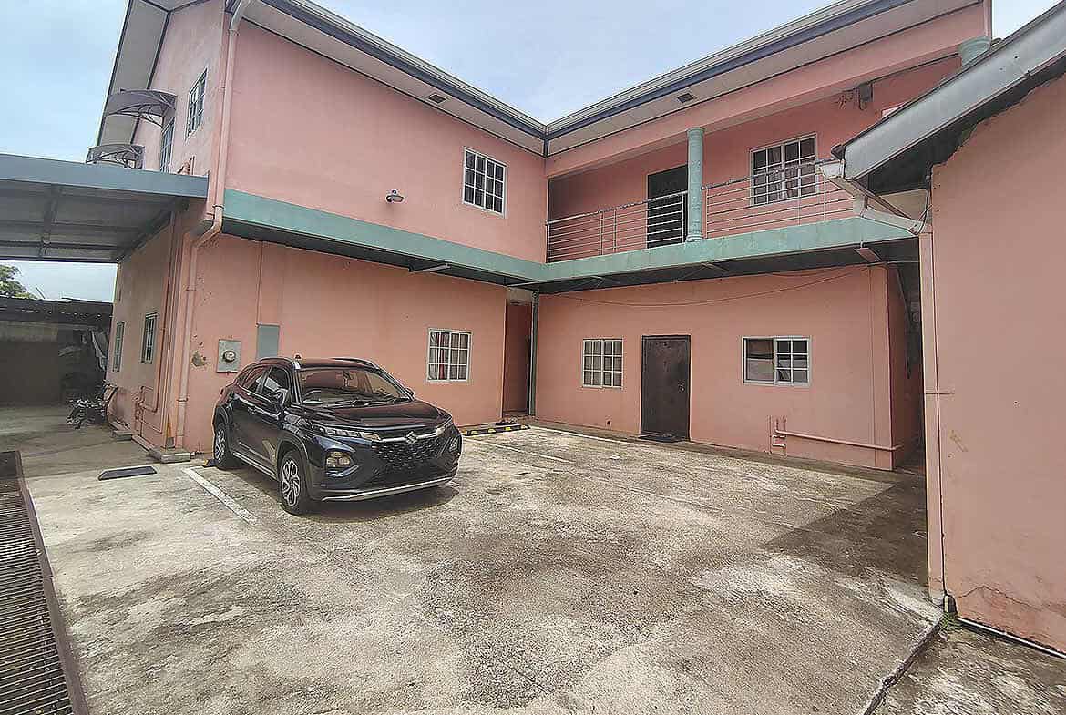 Cornerstone- Pink residential building with parking area in Arima, Trinidad and Tobago.
