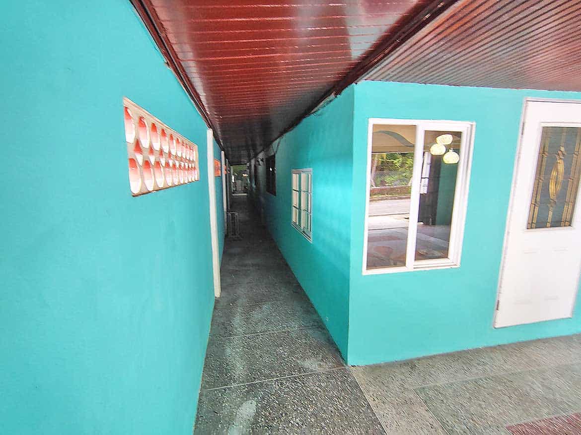 Cornerstone™ Alexander Street Building Narrow corridor between turquoise buildings with windows and door.