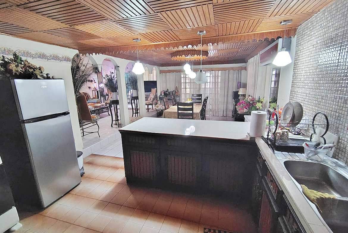 Spacious kitchen and dining area with wooden ceiling and modern appliances.