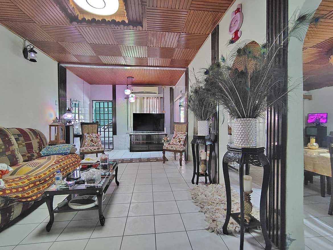 Cornerstone™ Living Room Interior Spacious living room with wooden ceiling, large TV, and decorative plants.
