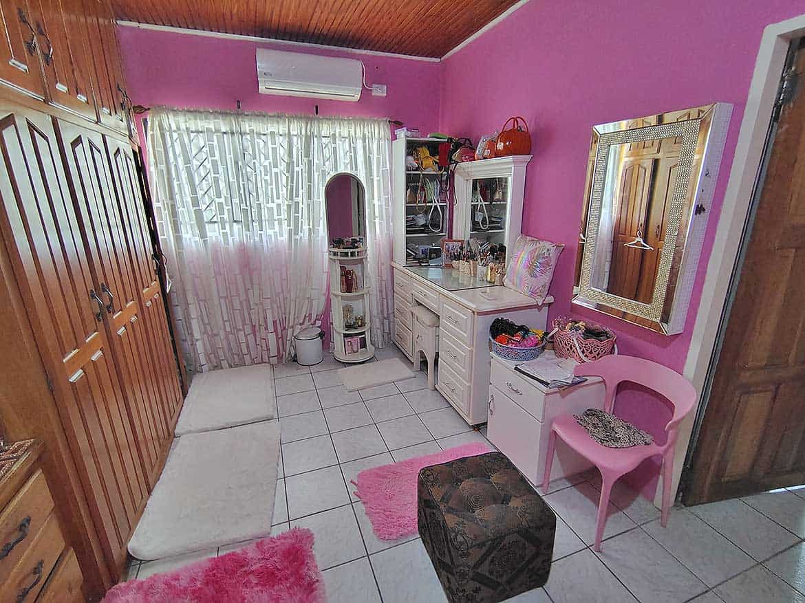 Alexander Street Bedroom with Pink Decor Cozy bedroom with pink walls, white furniture, and decorative accents.