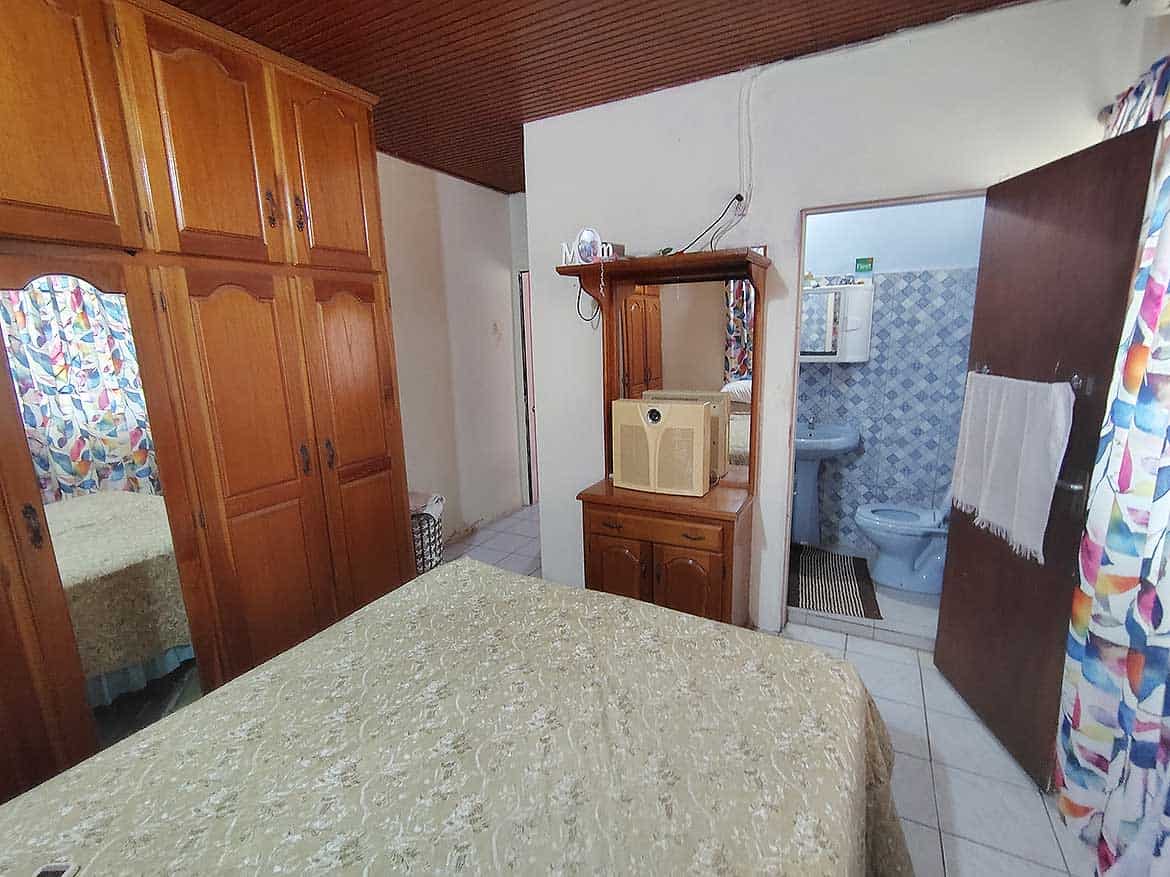 Cozy Bedroom with Wooden Wardrobes Bedroom with wooden wardrobes, a bed, and a view into the bathroom.