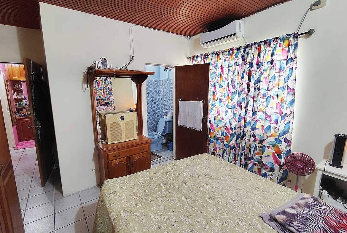Cozy bedroom with colorful curtains and wooden furniture.