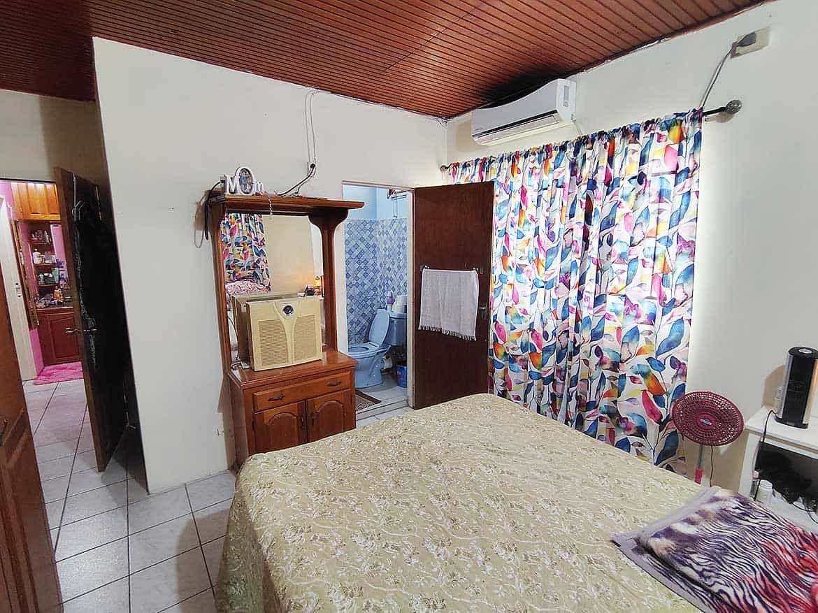 Cornerstone™ Bedroom Interior Cozy bedroom with colorful curtains and wooden furniture.