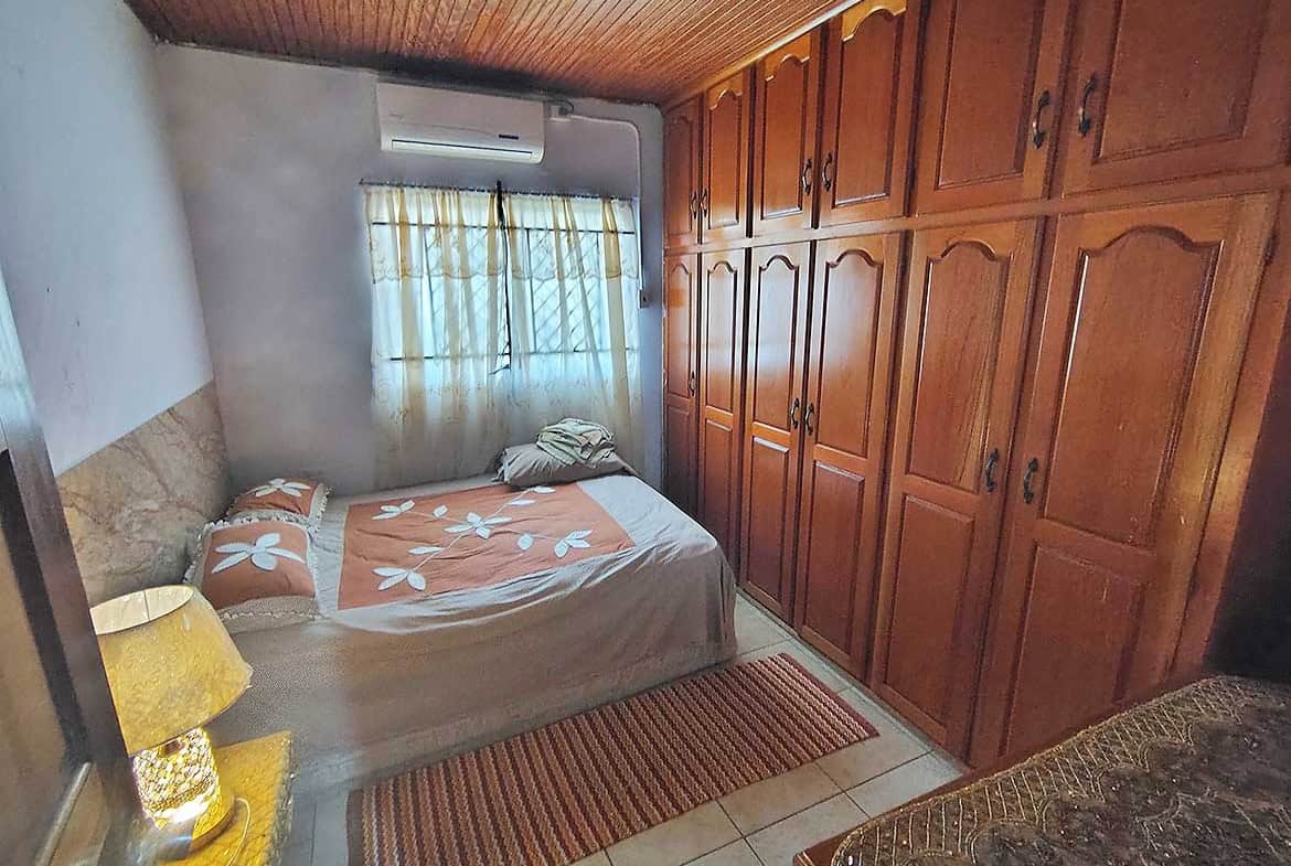 Comfortable bedroom with large wooden wardrobes and a bed with floral bedding.
