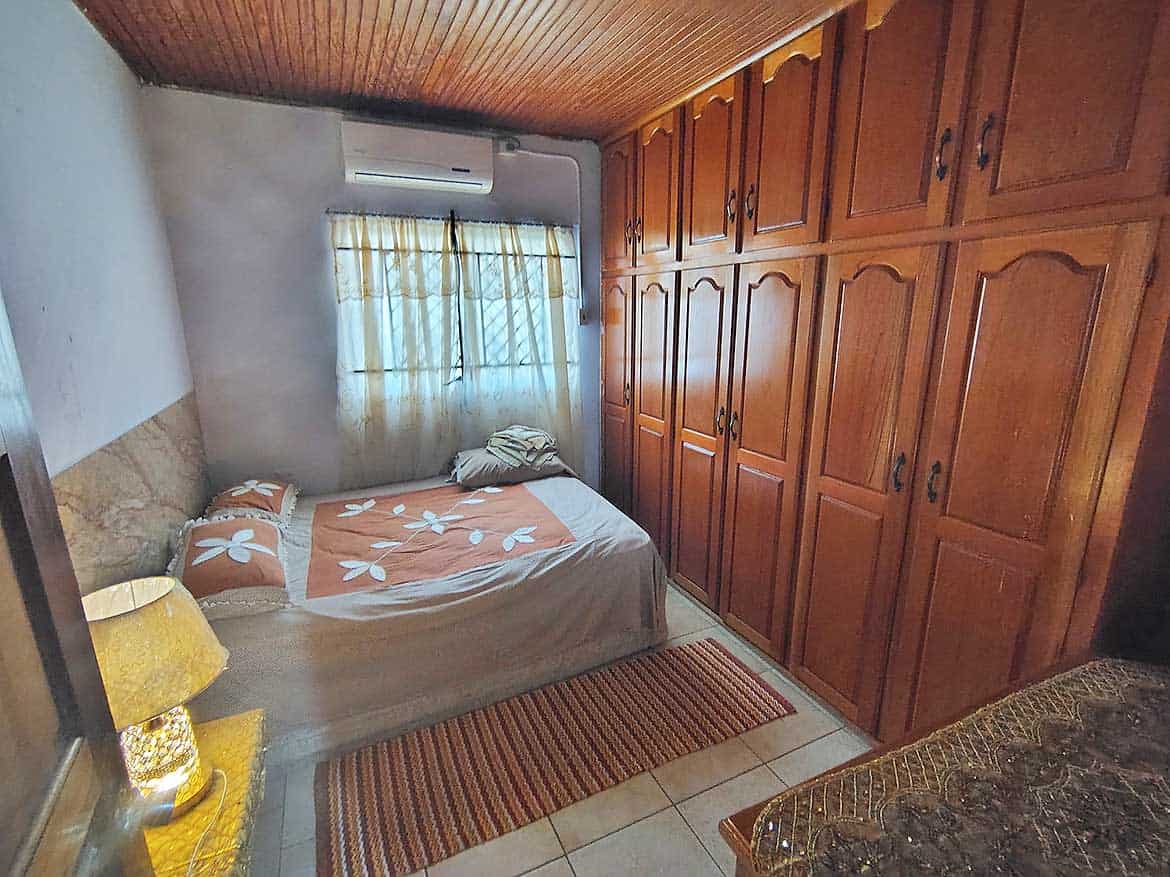 Cozy Bedroom with Wooden Wardrobes Comfortable bedroom with large wooden wardrobes and a bed with floral bedding.