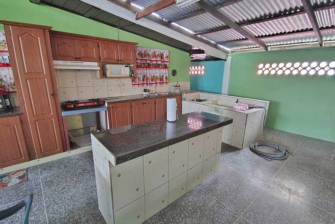 Spacious kitchen with green walls, wooden cabinets, and a central island.