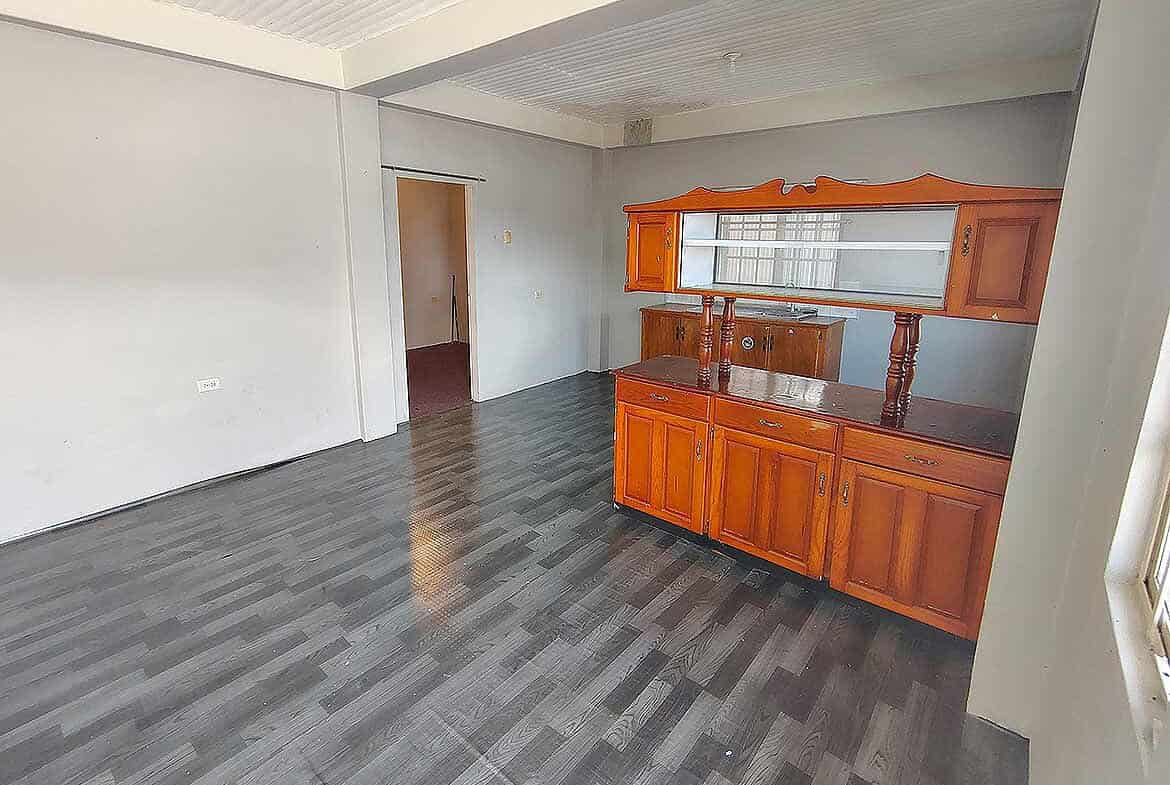 Cornerstone- Spacious living room with wooden cabinet and gray flooring in EMR Tacarigua Apt 4.
