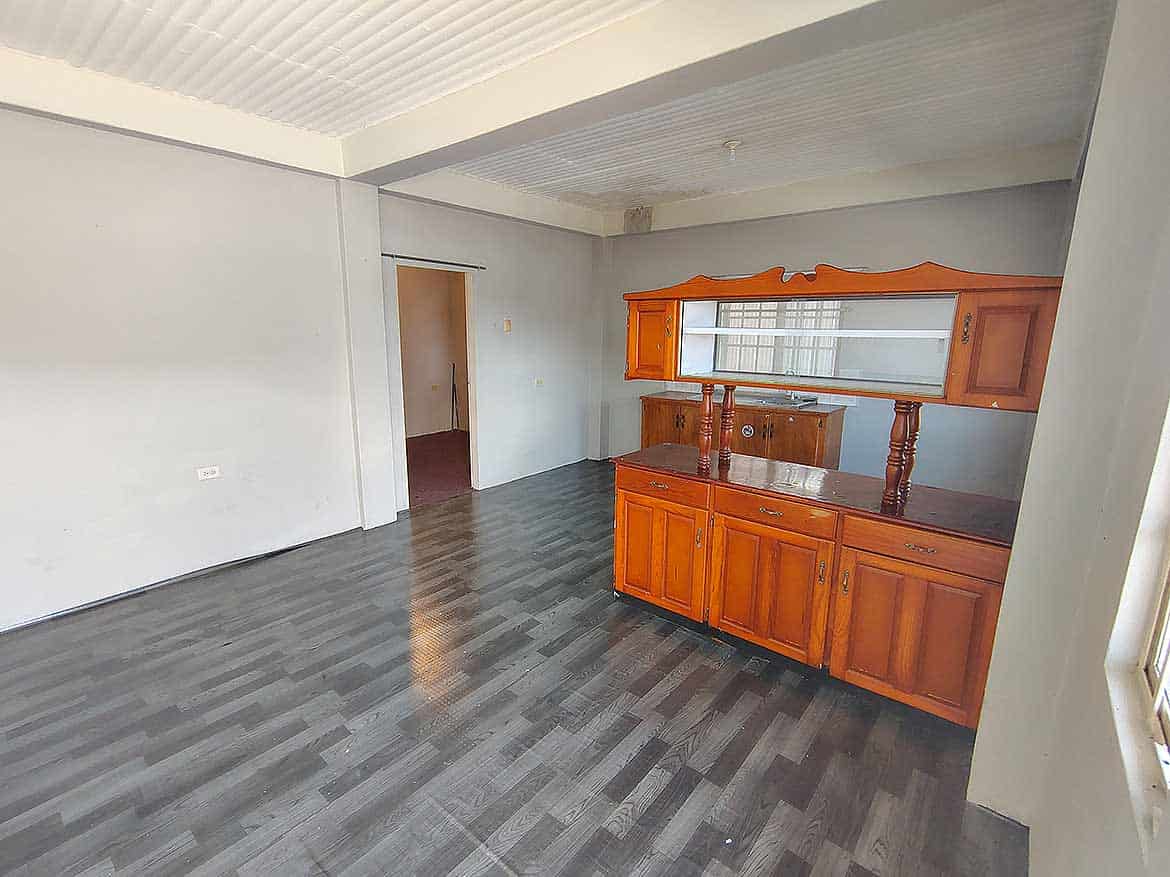 Living Room in EMR Tacarigua Apt 4 Cornerstone- Spacious living room with wooden cabinet and gray flooring in EMR Tacarigua Apt 4.