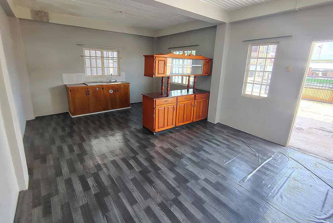 Cornerstone- Spacious living room with wooden cabinets and large windows in Cornerstone™ EMR Tacarigua Apt 4.