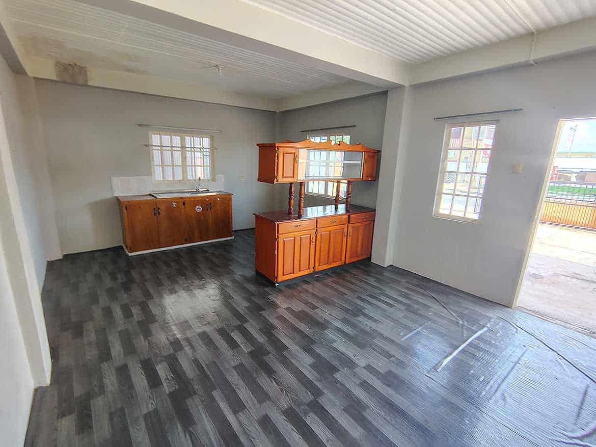 Interior of Cornerstone™ EMR Tacarigua Apt 4 Cornerstone- Spacious living room with wooden cabinets and large windows in Cornerstone™ EMR Tacarigua Apt 4.