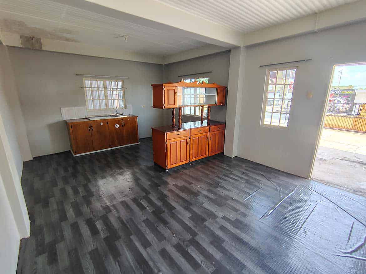 Interior of Cornerstone™ EMR Tacarigua Apt 4 Cornerstone- Spacious living area in Cornerstone™ EMR Tacarigua apartment with wooden cabinets and large windows.