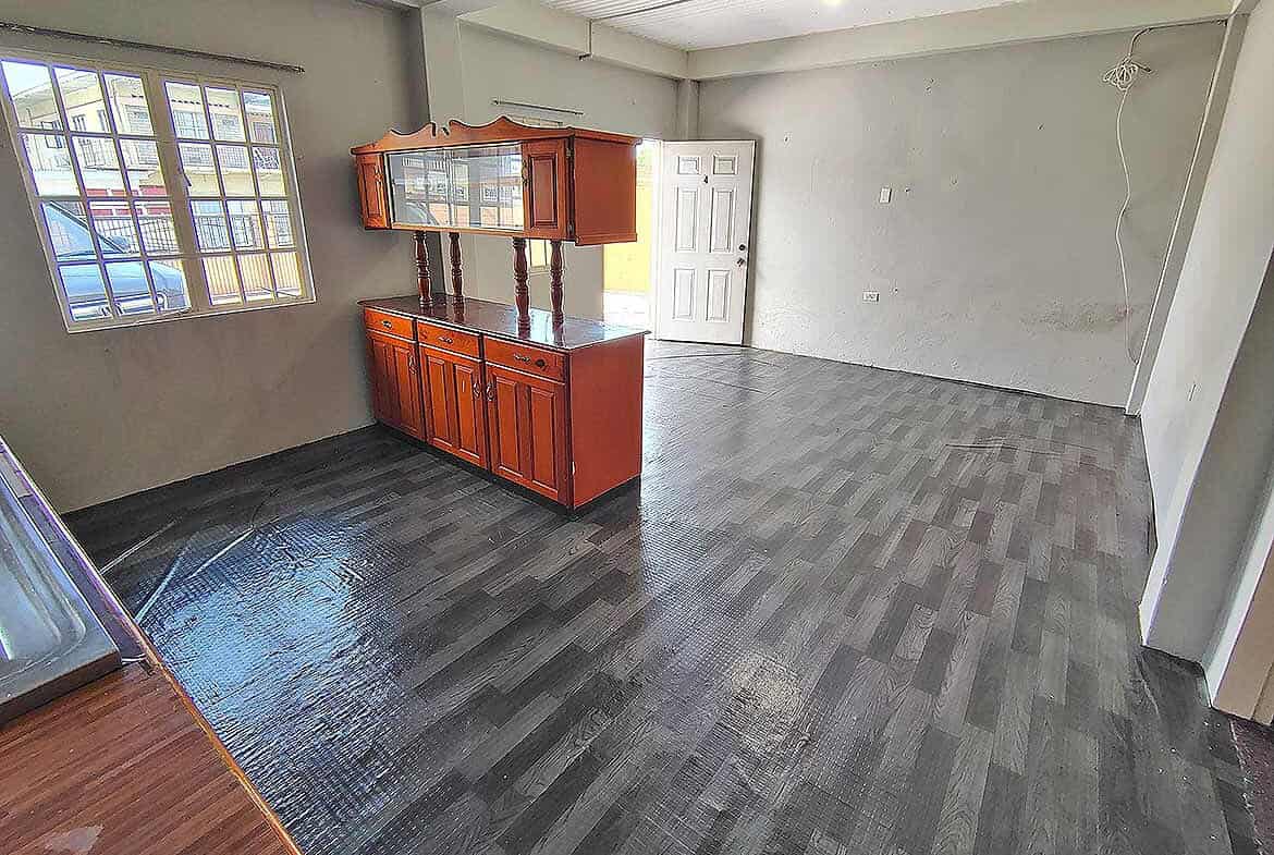 Cornerstone- Spacious living room with dark flooring and large window in EMR Tacarigua Apt 4.