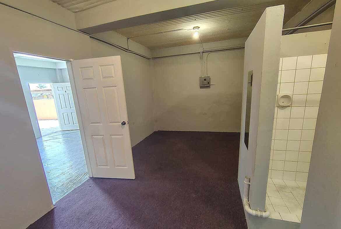 Cornerstone- Spacious room with open door and tiled shower area in EMR Tacarigua Apt 4.