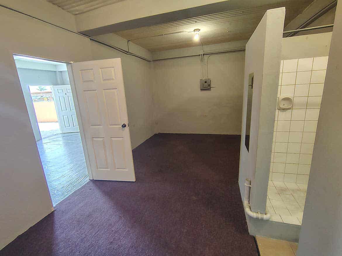 Interior of EMR Tacarigua Apt 4 Cornerstone- Spacious room with open door and tiled shower area in EMR Tacarigua Apt 4.