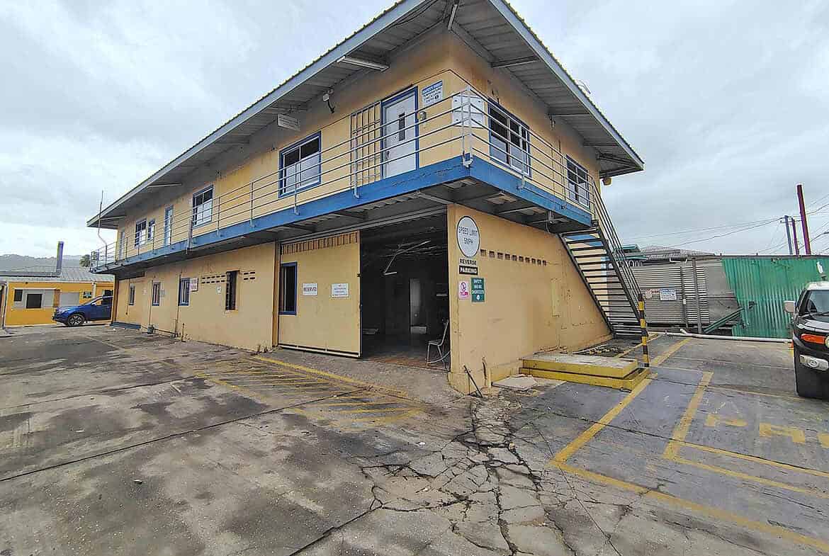 Cornerstone- Two-story commercial building with yellow walls and blue accents on Johnny King Road.