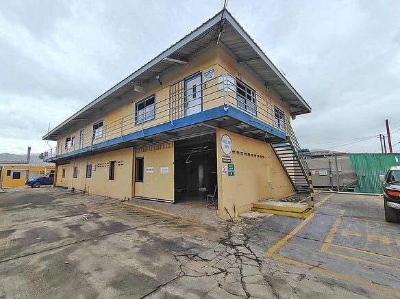 Cornerstone- Two-story commercial building with yellow walls and blue accents on Johnny King Road.