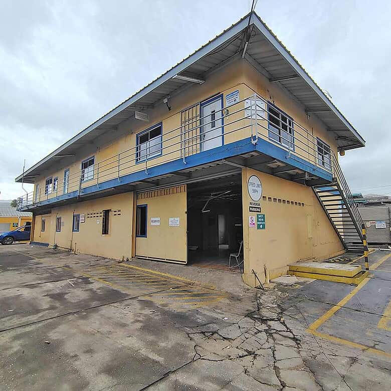 Cornerstone- Two-story commercial building with yellow walls and blue accents on Johnny King Road.