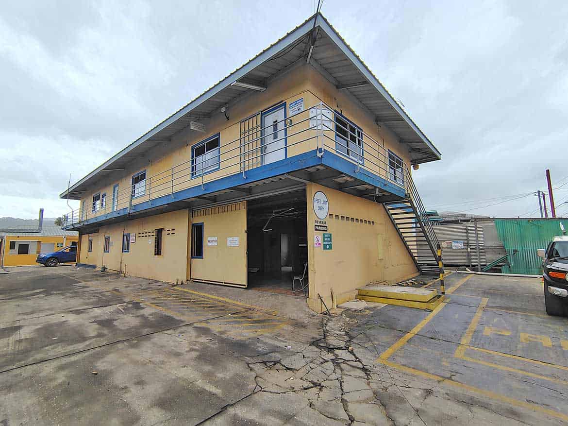 Cornerstone- Two-story commercial building with yellow walls and blue accents on Johnny King Road.