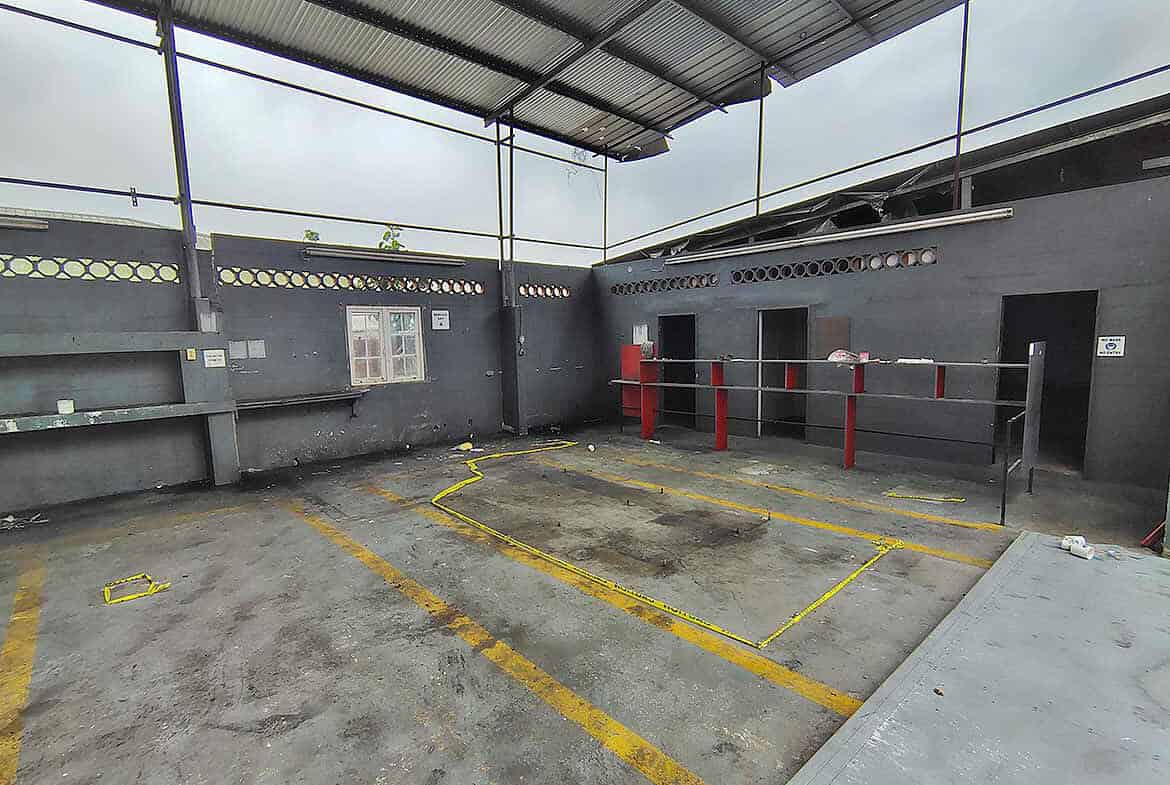 Cornerstone- Empty parking lot with marked spaces and a metal roof cover.
