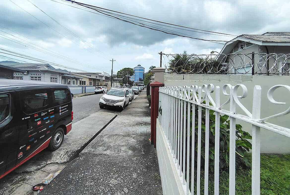 Cornerstone- Residential street view in Woodbrook with parked cars and houses.