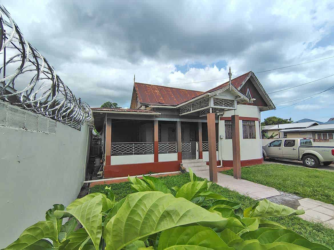Cornerstone™ Residential Home in Woodbrook Cornerstone- Residential house on Carlos Street, Woodbrook with garden and parked vehicle.