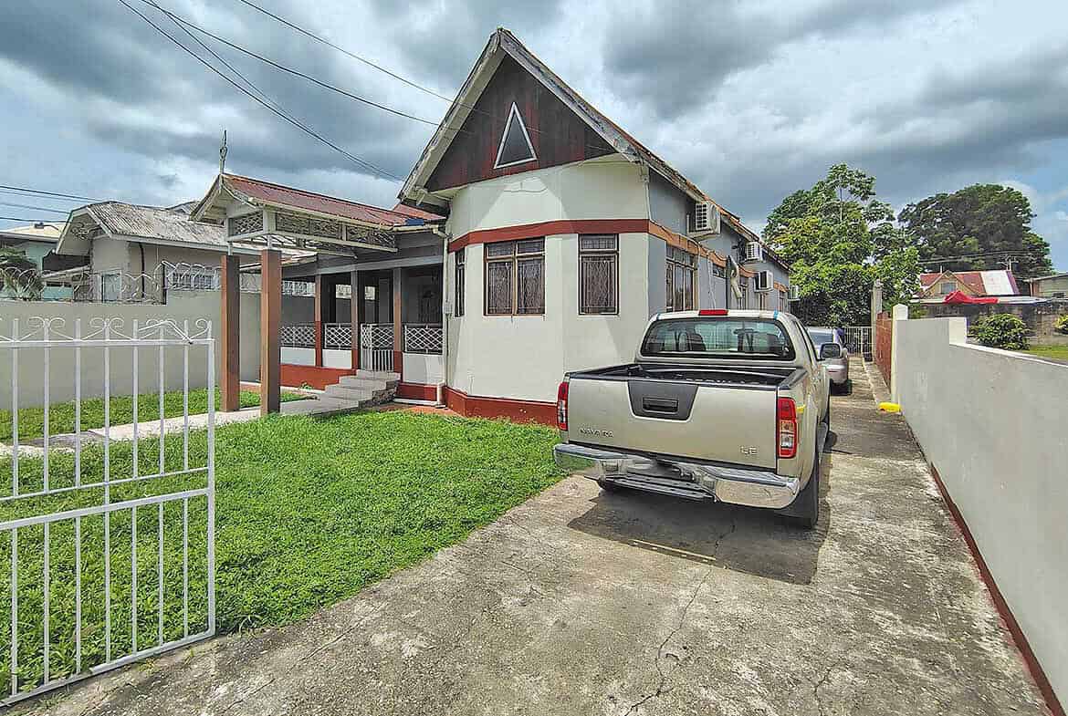 Cornerstone- Residential house on Carlos Street with parked truck and cloudy sky.