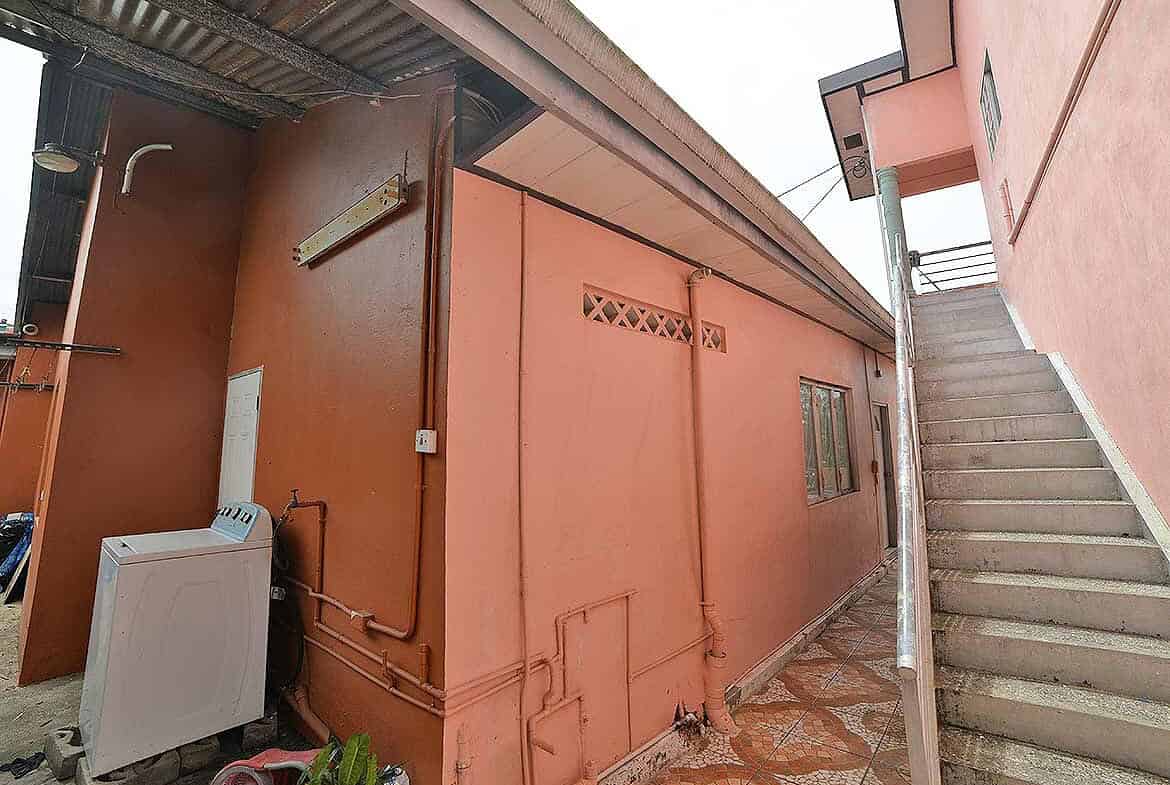 Cornerstone- Residential building on Cleaver Road, Arima with pink exterior walls and outdoor staircase.