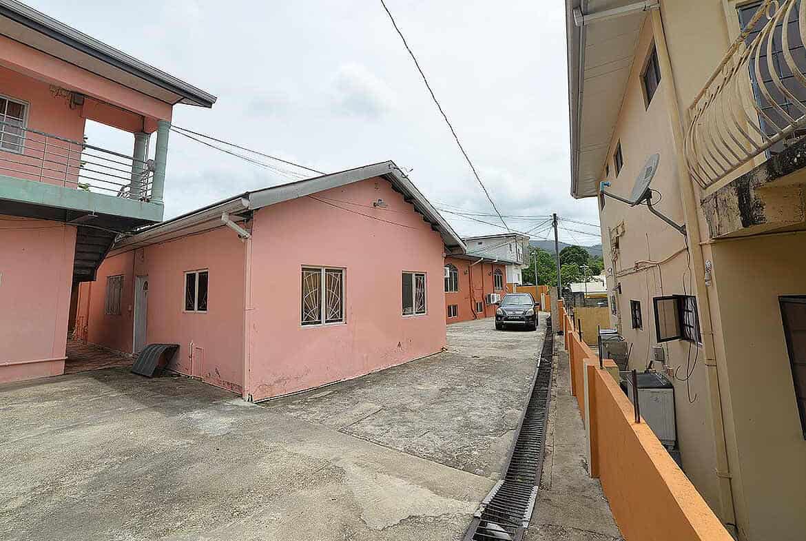 Cornerstone- Residential buildings on Cleaver Road, Arima, with parking and utility lines.