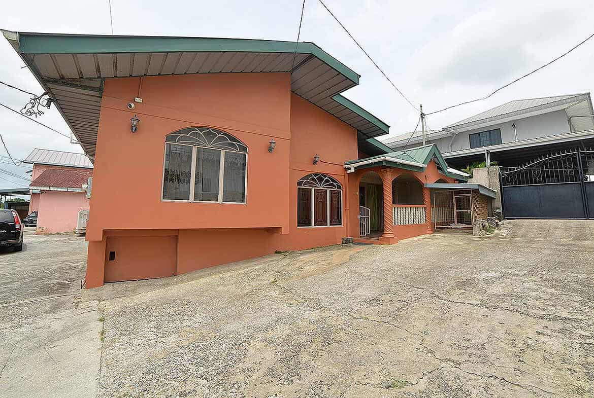 Cornerstone- Residential house on Cleaver Road, Arima with a peach exterior and green roof.