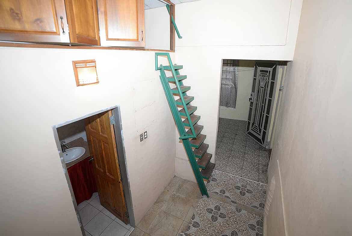 Cornerstone- Staircase inside Cornerstone™ property in Arima with wooden cabinets.