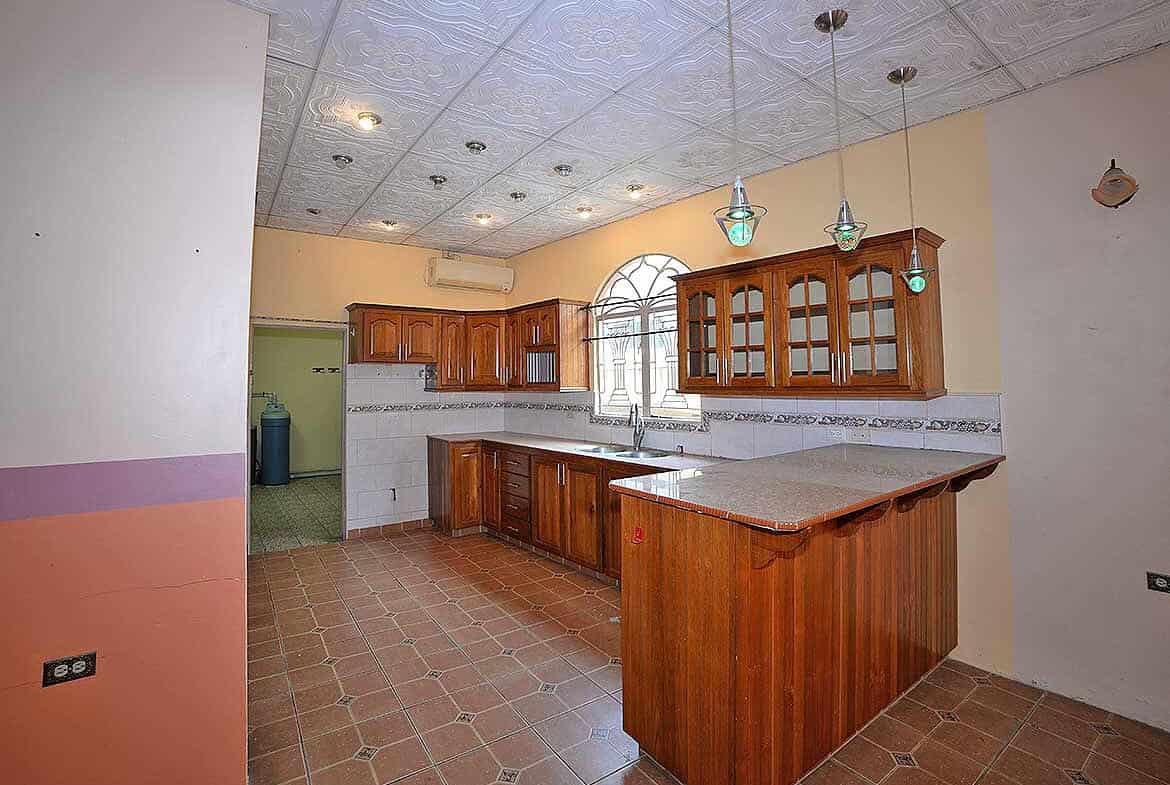 Cornerstone- Spacious kitchen with wooden cabinets and tiled flooring in Cleaver Road, Arima.