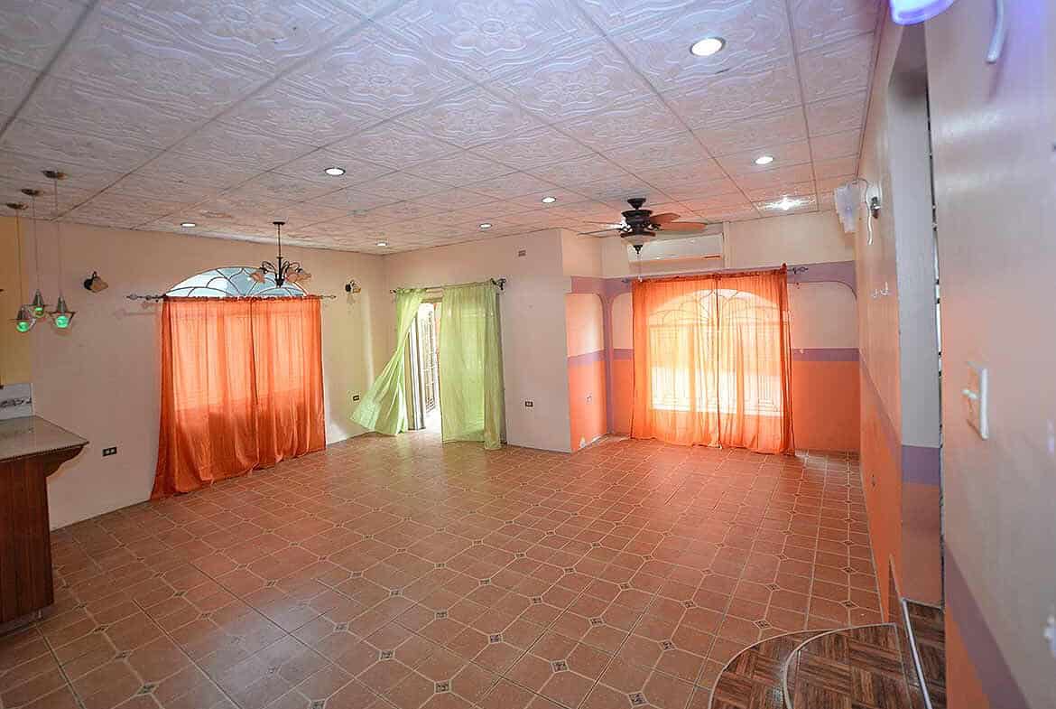 Cornerstone- Bright living room with colorful curtains and tiled floor in Arima property.