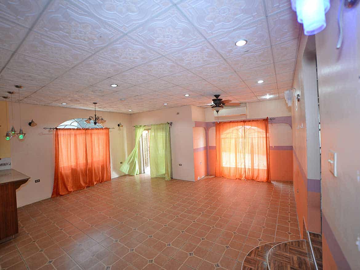 Spacious Living Room in Cleaver Road, Arima Cornerstone- Bright living room with colorful curtains and tiled floor in Arima property.