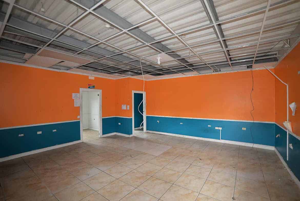 Cornerstone- Empty room with orange and blue walls and tiled floor at Cornerstone™.