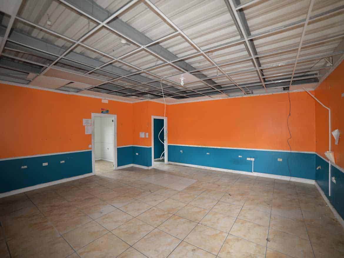 Interior of Cornerstone™ Facility Cornerstone- Empty room with orange and blue walls and tiled floor at Cornerstone™.
